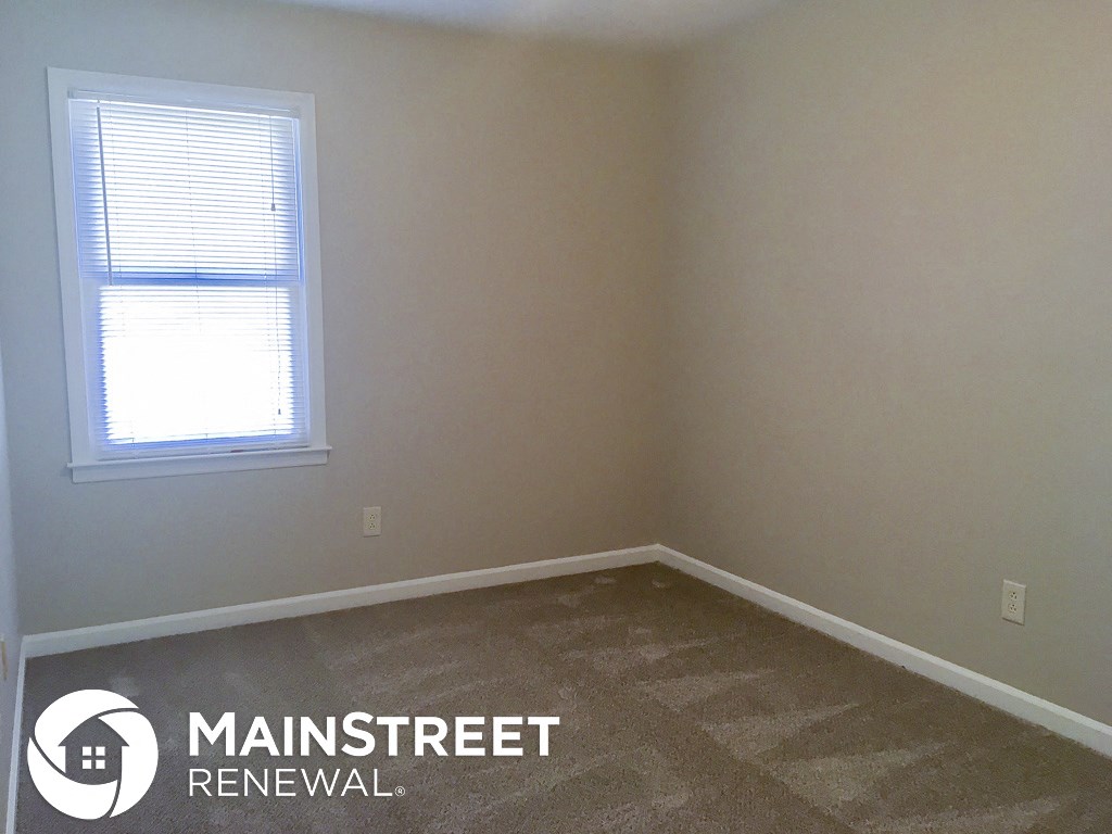 a small room with a window and a carpeted floor