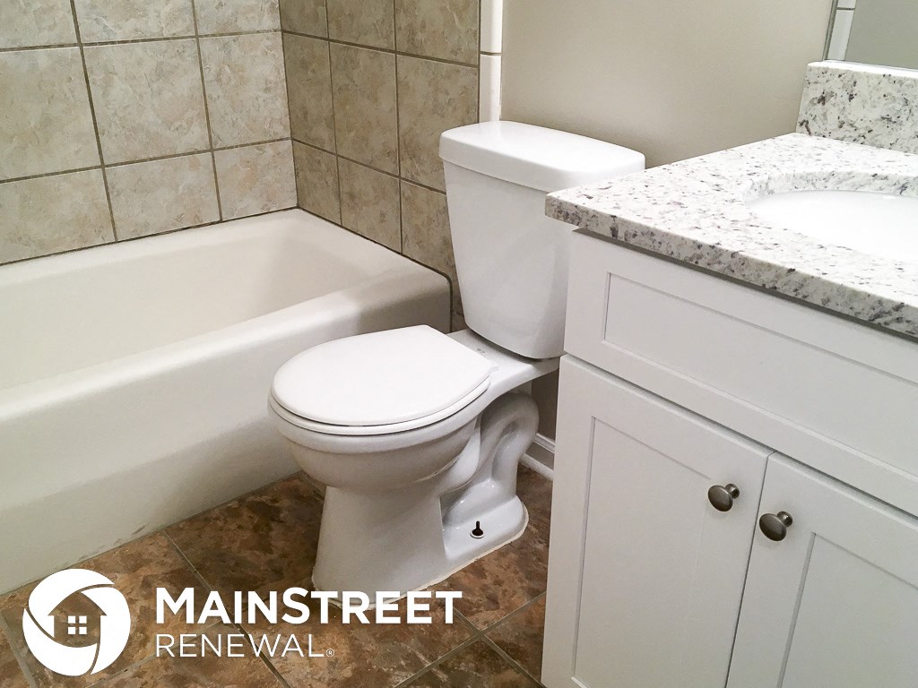 an image of a bathroom with a toilet and a tub