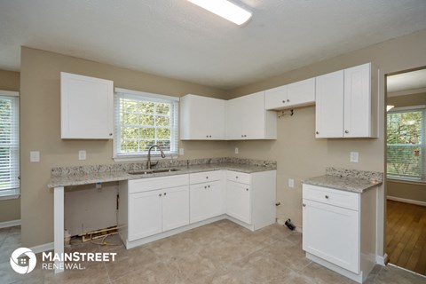 a kitchen with white cabinets and granite counter tops