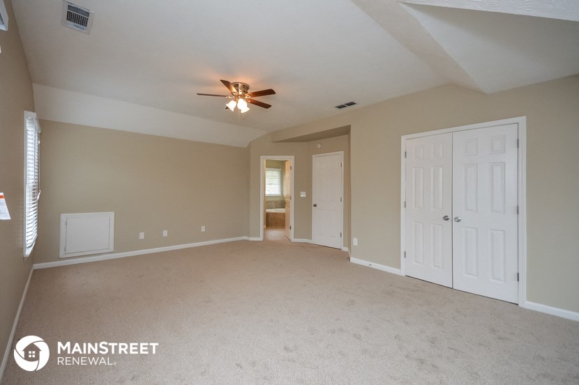 the master bedroom is spacious and has a ceiling fan