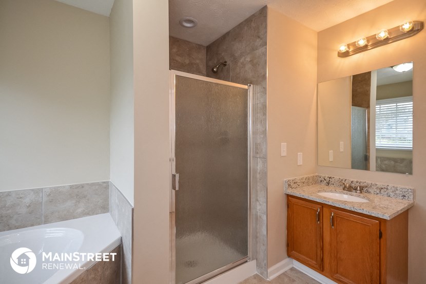 a bathroom with a shower and a sink and a mirror