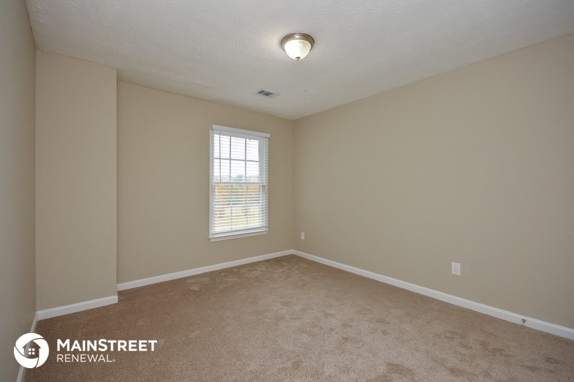 the upstairs bedroom with carpet and window