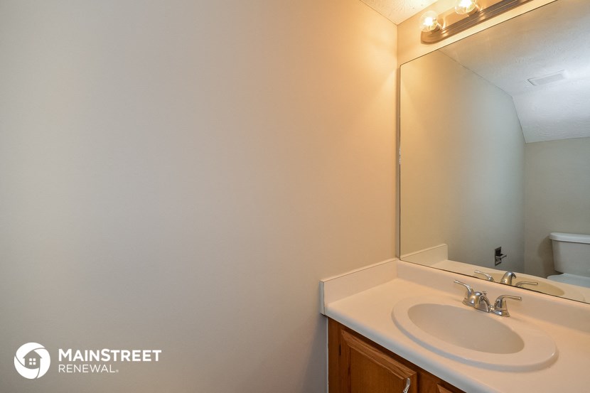 a bathroom with a white sink and a large mirror