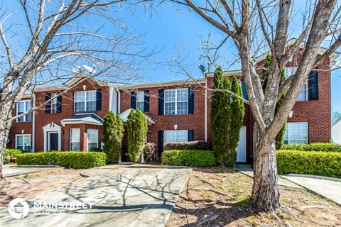 a large brick house with trees in front of it