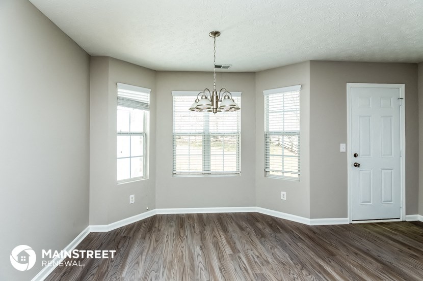 the living room of a new home with wood floors and a chandelier