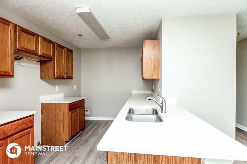 a kitchen with a sink and wooden cabinets