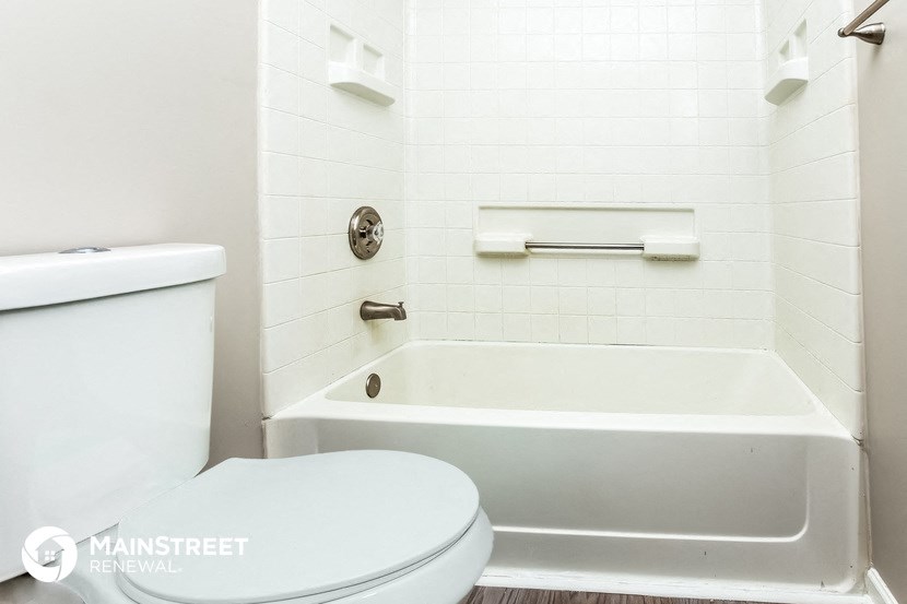 a white bathroom with a toilet and a tub