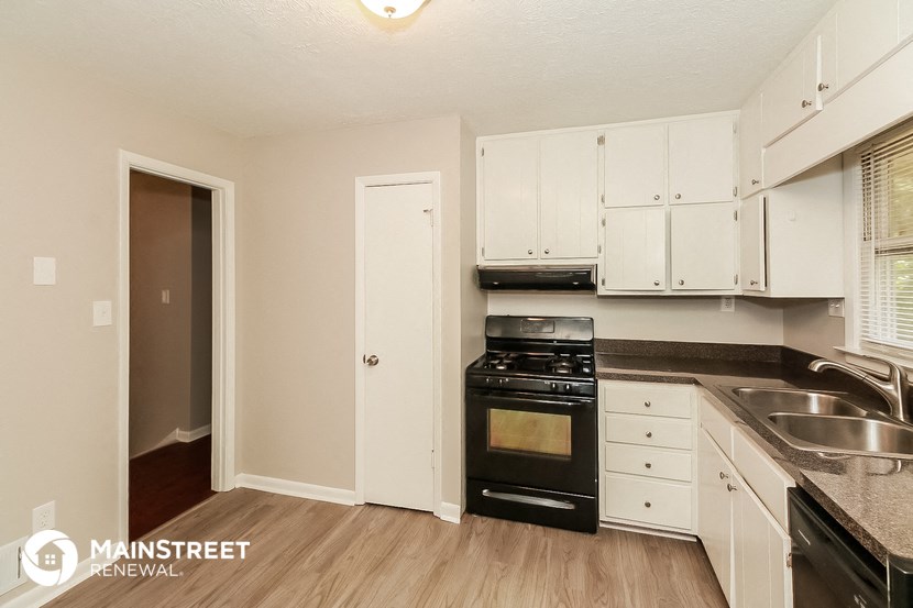 a kitchen with black appliances and white cabinets