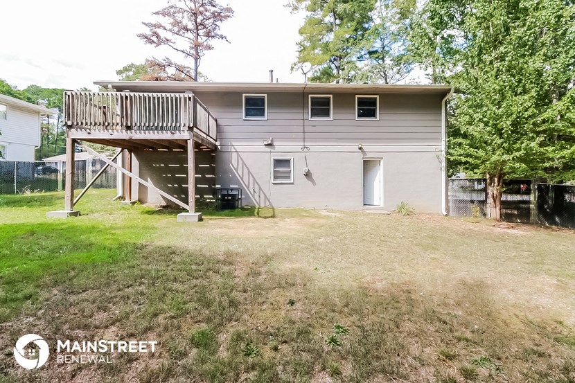 the back of a house with a deck on top of it