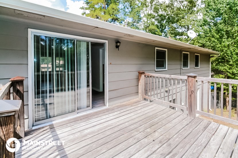 a deck with a sliding glass door to a house
