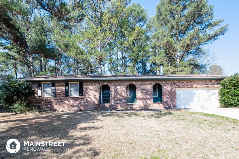 an old brick house with green doors and windows