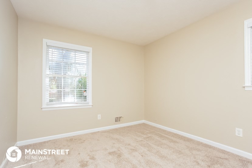 a bedroom with a carpeted floor and a window