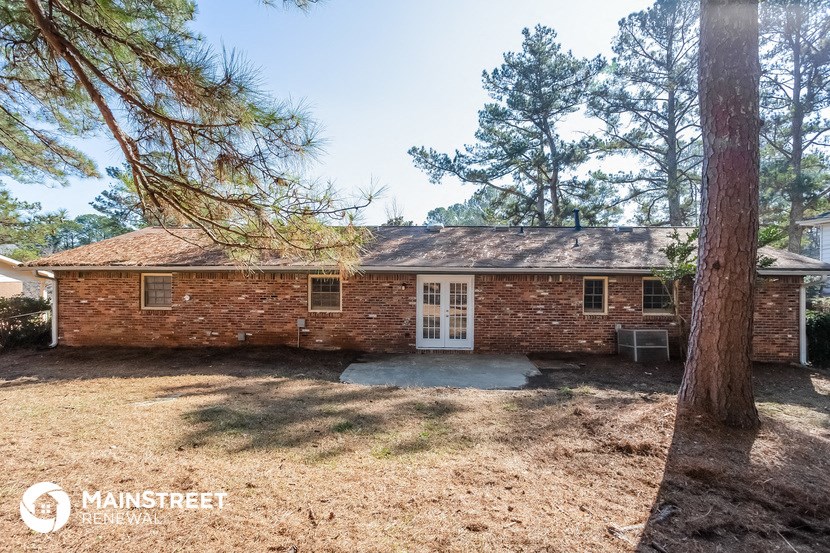 a brick house with a large pine tree in front of it