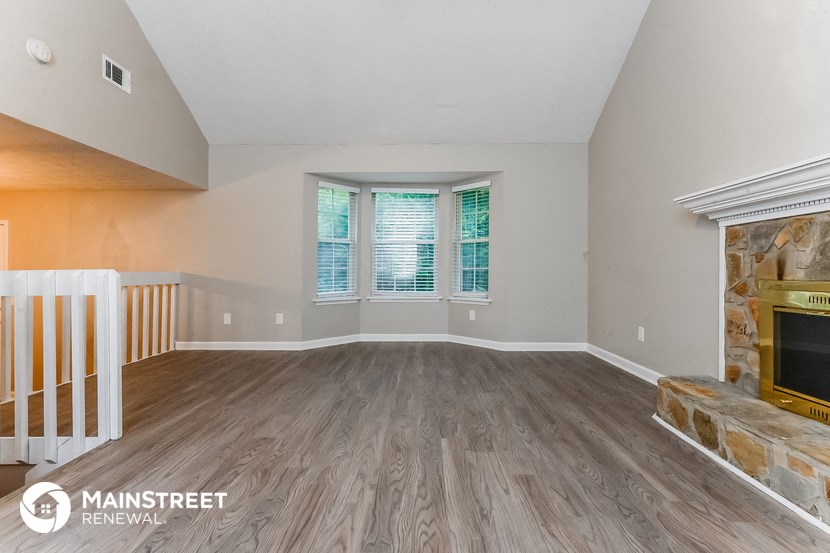 a living room with wood floors and a fireplace