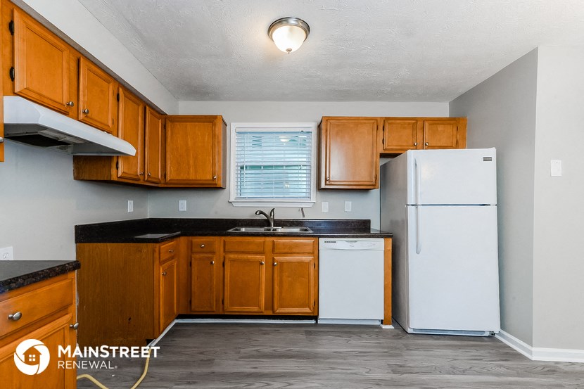 a kitchen with wooden cabinets and a white refrigerator
