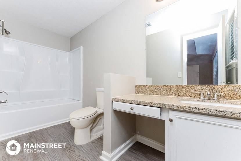 a bathroom with a toilet and a sink and a bath tub