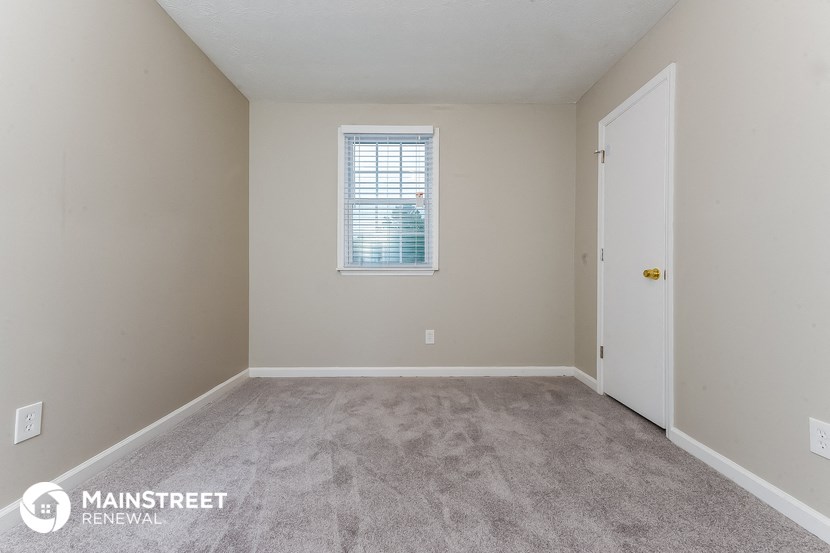 a bedroom with a carpeted floor and a window