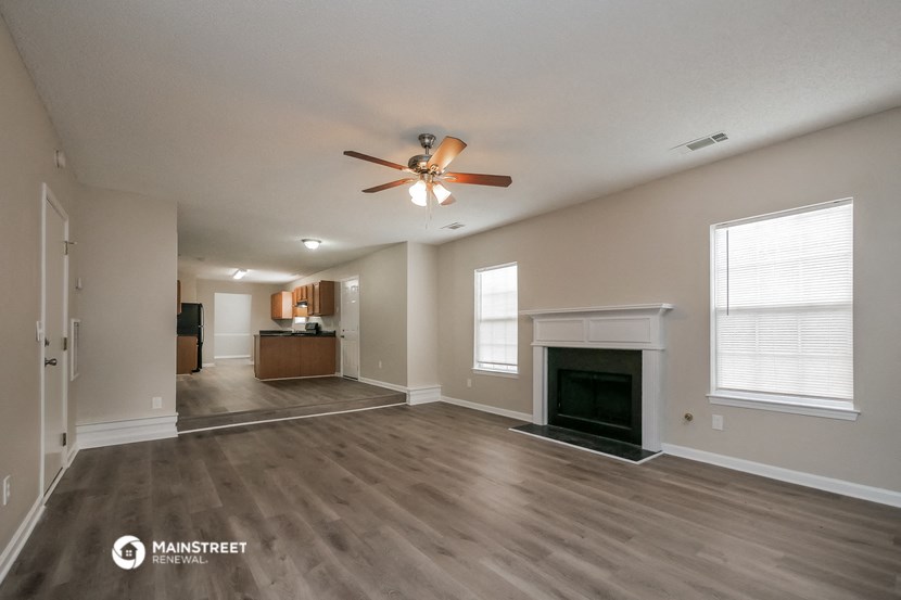 the living room with fireplace and ceiling fan