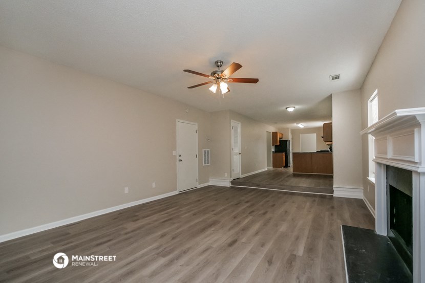 a living room with a fireplace and a ceiling fan