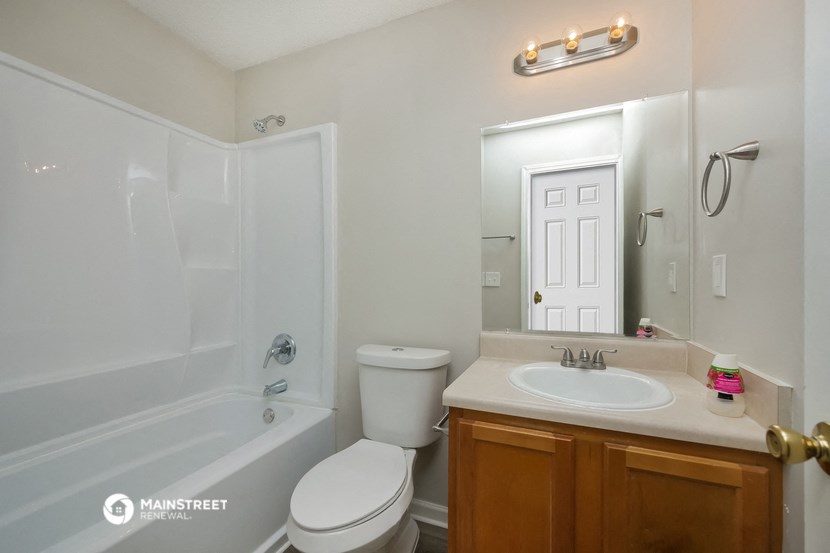 a bathroom with a sink toilet and tub and a mirror