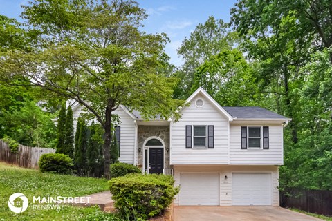 a white house with black shutters and a driveway