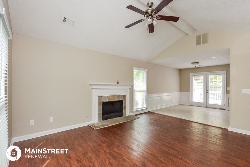 a living room with a fireplace and a ceiling fan