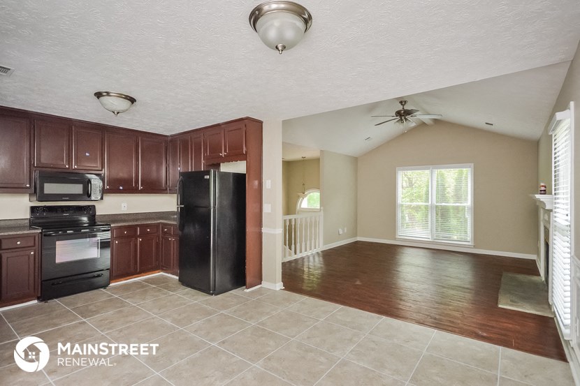 an empty kitchen with black appliances and wooden cabinets