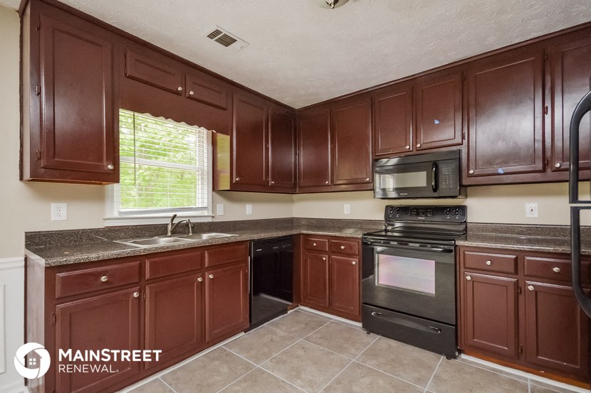 a kitchen with dark wood cabinets and stainless steel appliances