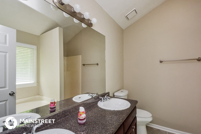 the master bathroom has dual sinks and a large mirror