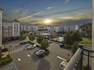 an aerial view of a parking lot at sunset with apartment buildings