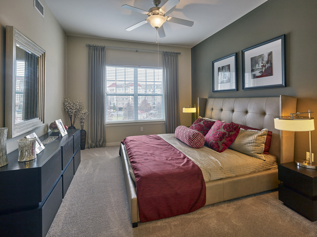 a bedroom with a bed and a ceiling fan