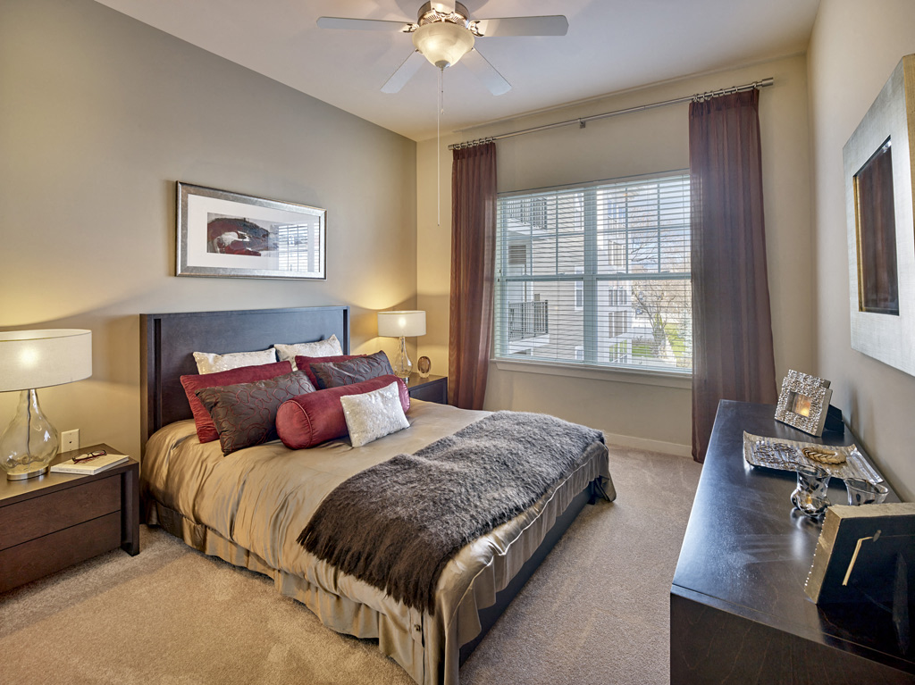 a bedroom with a large bed and a ceiling fan