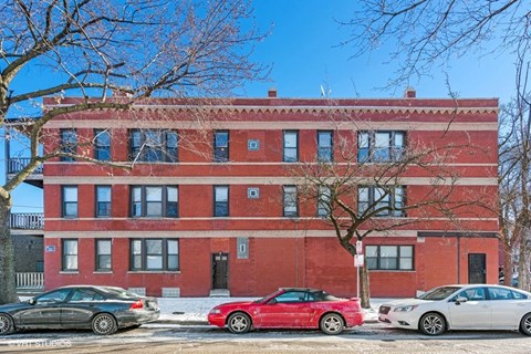a red brick building with cars parked in front of it