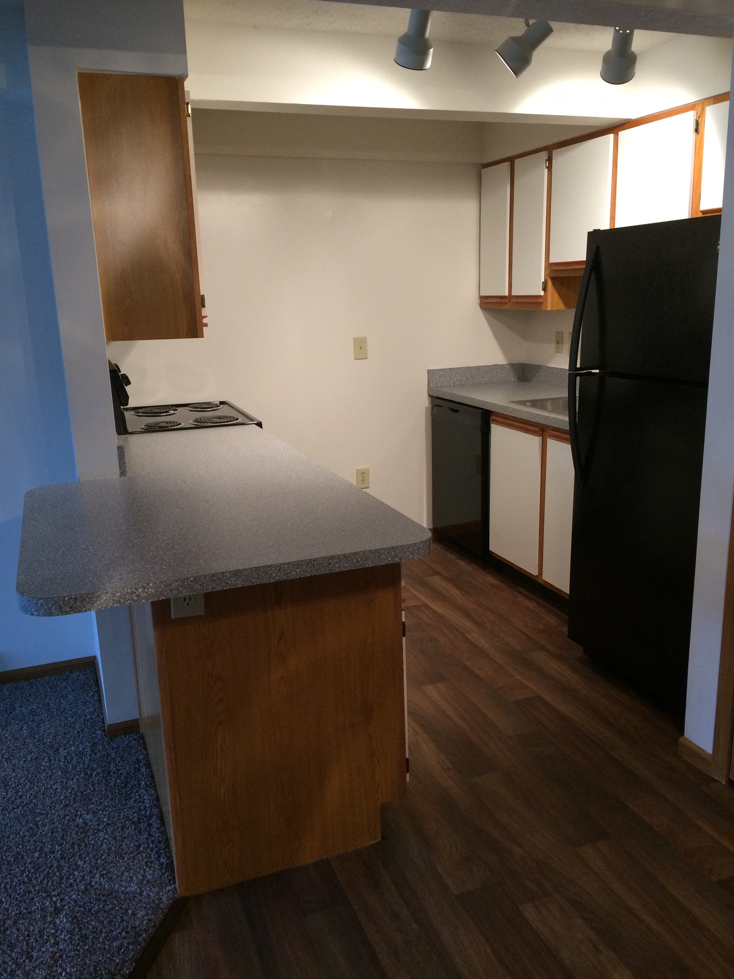 a kitchen with a counter and a black refrigerator