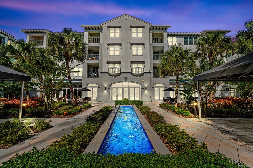 A large building with a pool in front of it.