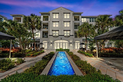 A large building with a pool in front of it.