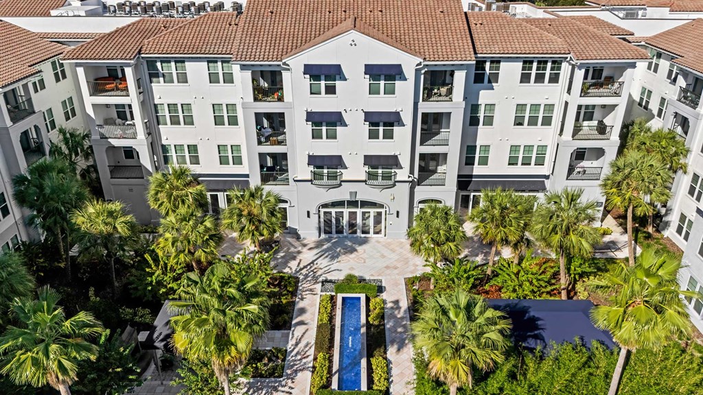 A large white building with a pool in front.