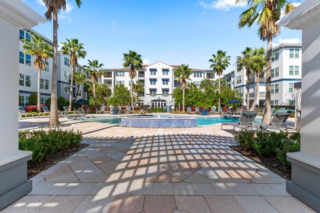 A sunny day at a resort with a pool and palm trees.