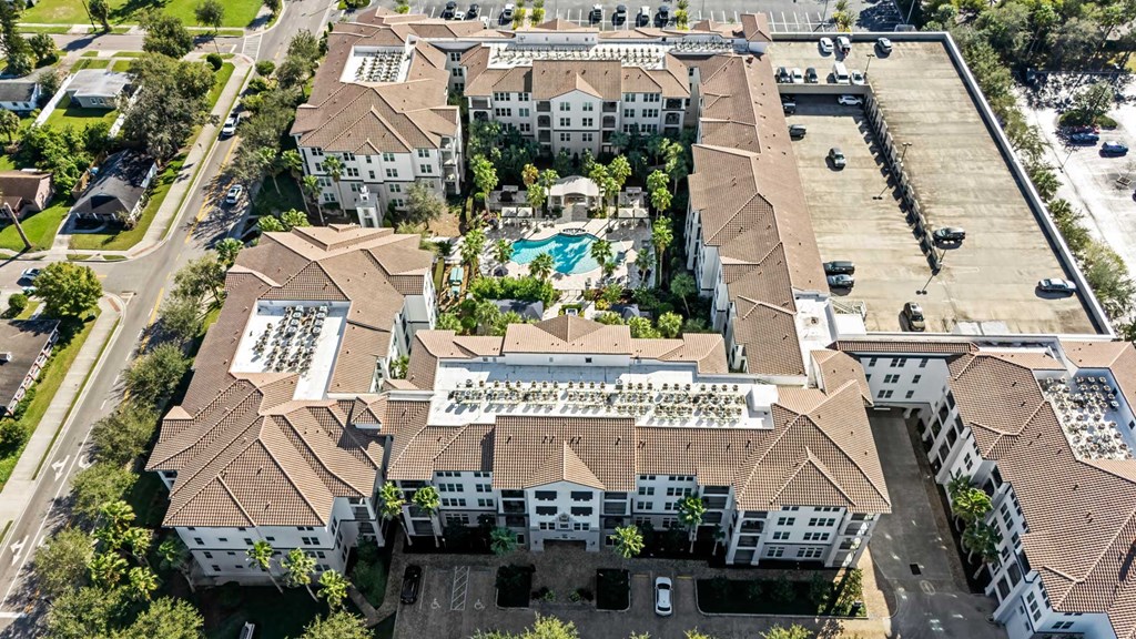 An aerial view of a large building with a pool in the middle.