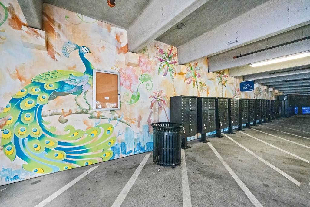 A parking garage with a mural of a peacock on the wall.