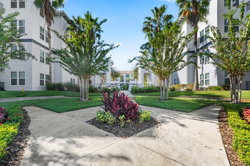 A white building with a green lawn in front.