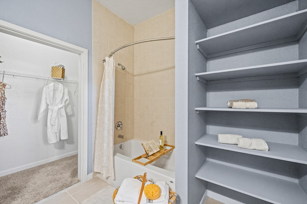 A bathroom with a white towel hanging on a rack and a white bathtub with a shower curtain.