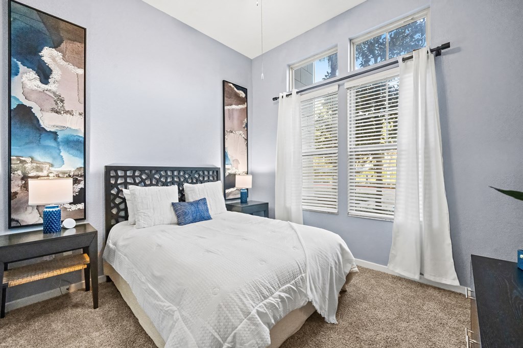 A bedroom with a large bed and a painting on the wall.
