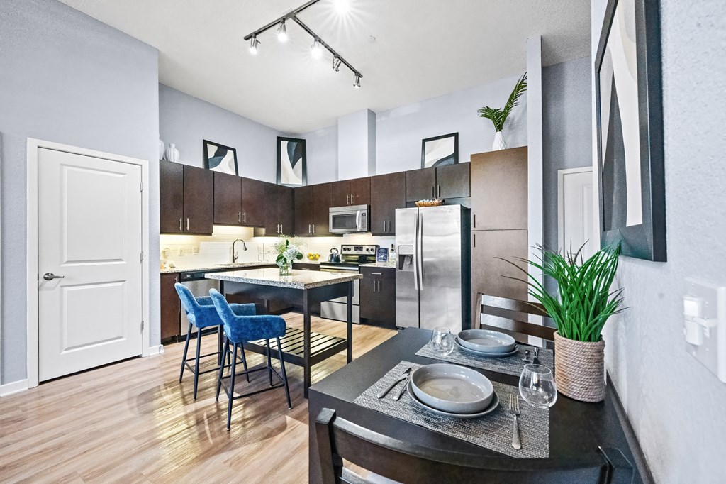 A modern kitchen with a dining table set for two.
