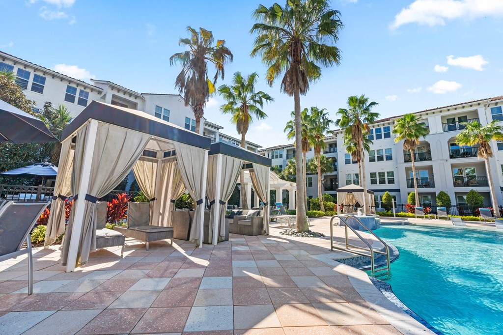 A pool area with a canopy and a pool in the foreground.