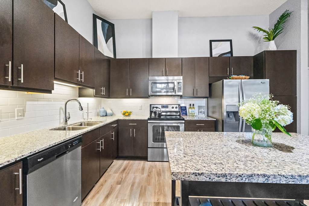 A kitchen with brown cabinets and a granite countertop.