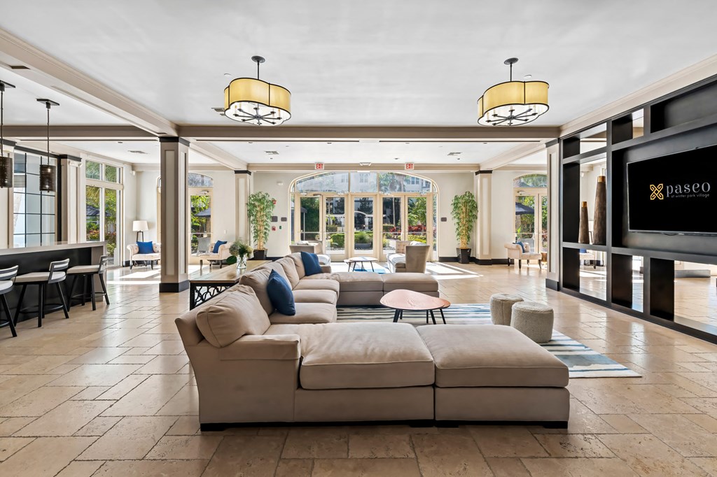 A living room with a large sectional sofa and a flat screen TV.