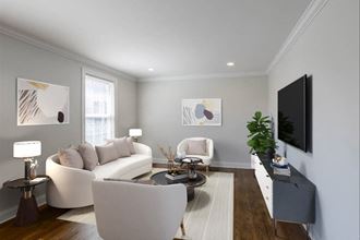 a living room with white furniture and a tv