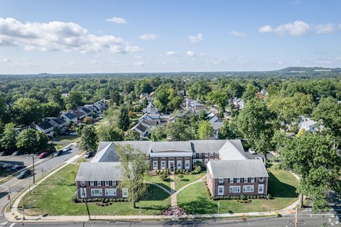 a view of a building from the air with a street and trees