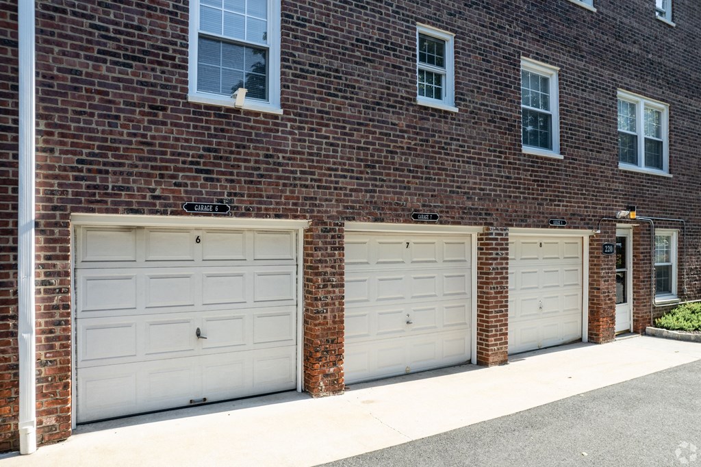 three garage doors on the side of a brick building